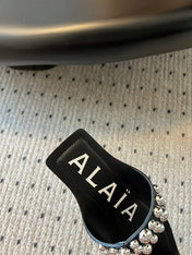 ALAIA FOLDED FLAT MULES WITH SPHERES ON BLACK CALFSKIN