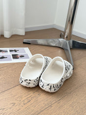 POOL GRAFFITI CROCS SLIDE SANDALS IN WHITE AND BLACK RUBBER